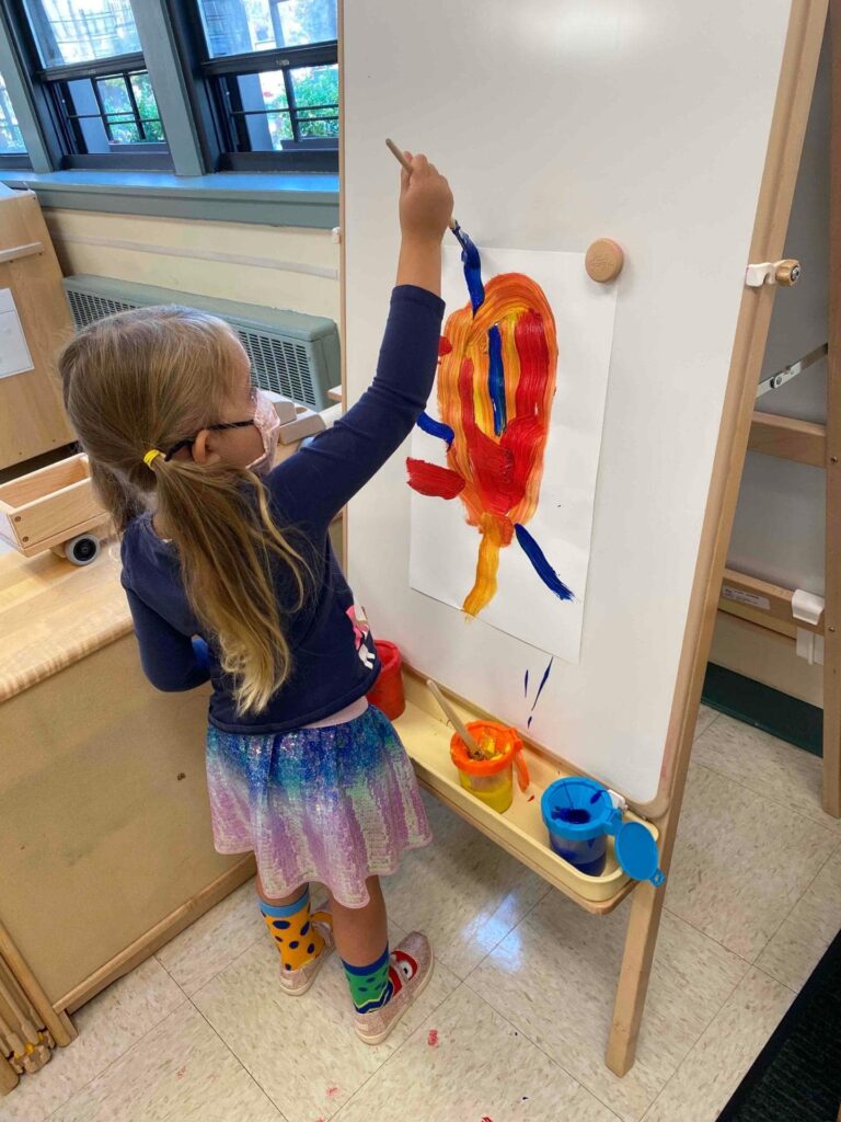 student painting on easel