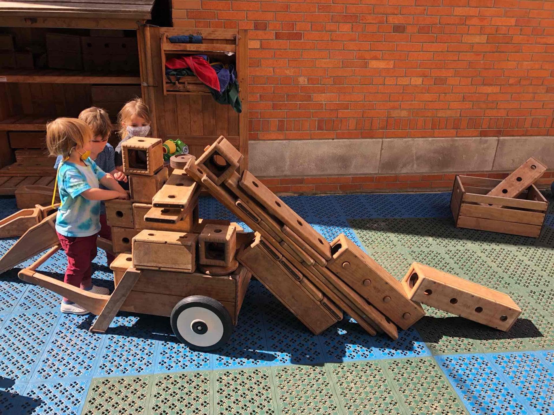 students in playground with wood toys